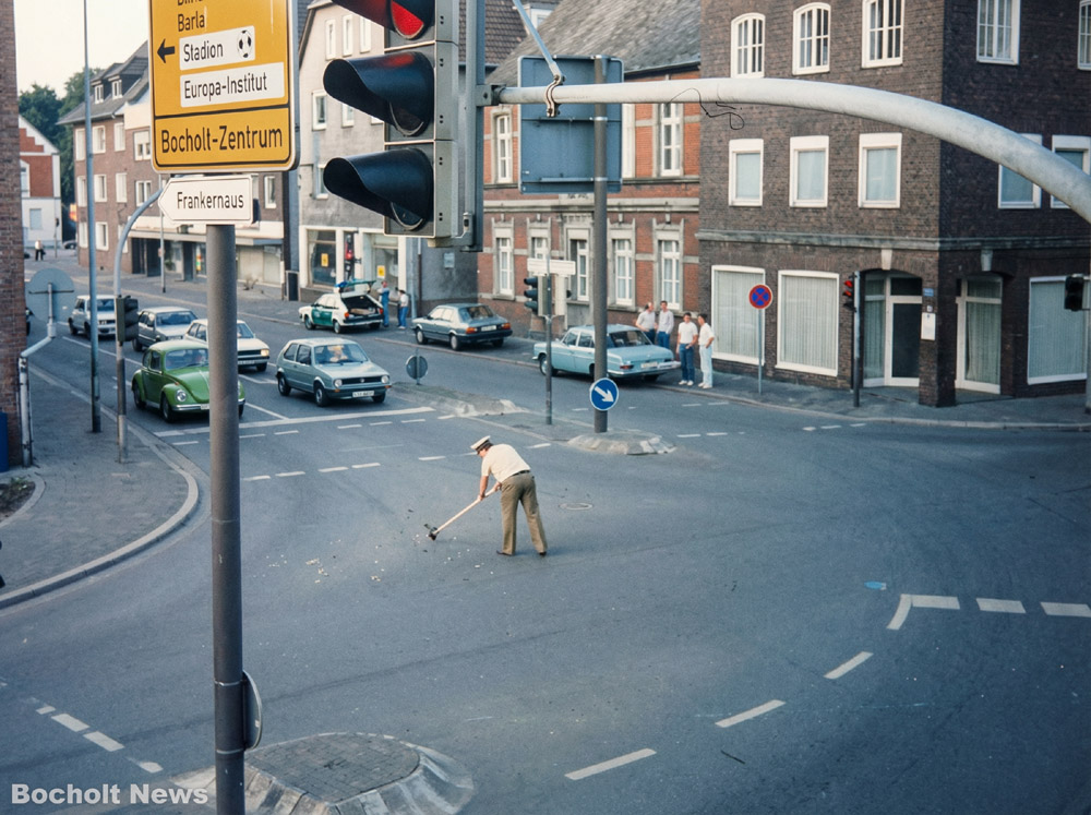 EIN POLIZIST FEGT IN DEN 80ER JAHREN DIE BOCHOLTER KREUZUNG NORDSTRASSE NORDWALL NACH EINEM UNFALL
